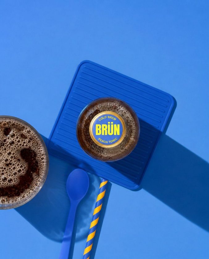 Bottle-cap table tennis paddle beside a glass of BRÜN cold brew