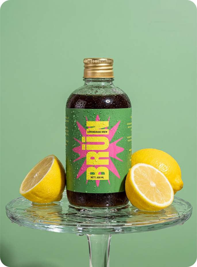 BRÜN Cold Brew Lemongrass bottle with lemon halves on a glass stand